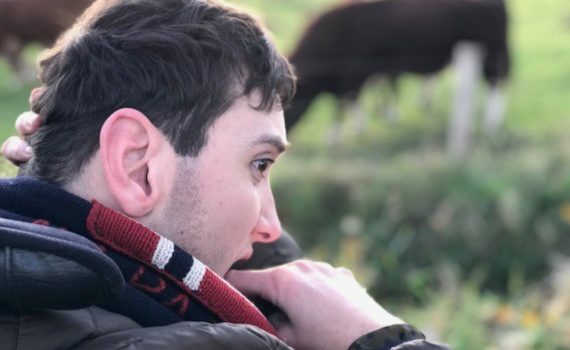 Marijn buiten met koe op achtergrond